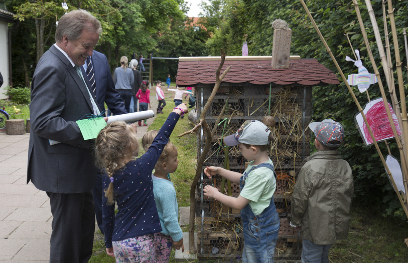 Kinder zeigen Herr Untersteller ihr selbstgebautes Insektenhotel