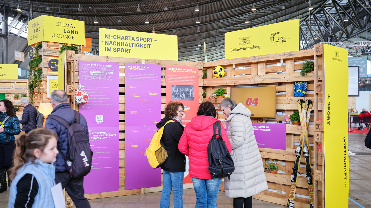Besucherinnen und Besucher betrachten die Informationstafeln der KLIMA.LÄND.LOUNGE zum Projekt N!-Charta SportProjekt NC