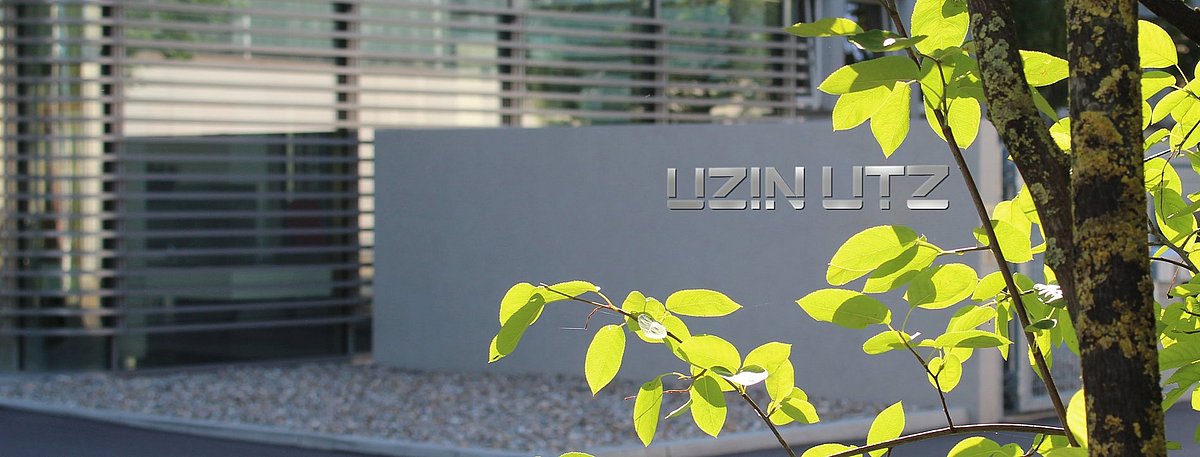 Der Hauptsitz der Uzin Utz AG befindet sich in einem modernen Kubus-Gebäude mit großen Glasfronten.