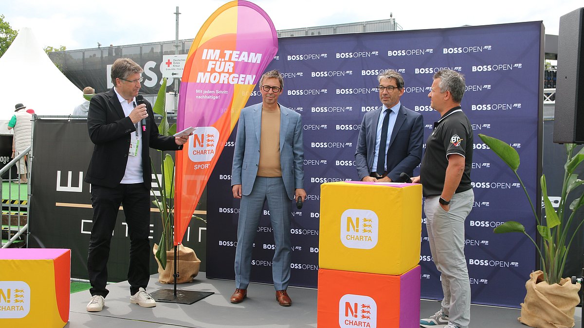 Der Umweltsstaatssekretär Dr. Andre Baummann im Gespräch auf dem Podium der N!-Charta Sport Urkundenübergabe.