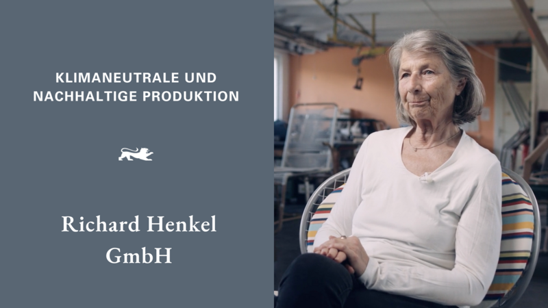 Links die Aufschrift auf grauem Hintergrund: Klimaneutrale und nachhaltige Produktion – Richard Henkel GmbH. Rechts Susanne Henkel, die Geschäftsführerin des Unternehmens. 