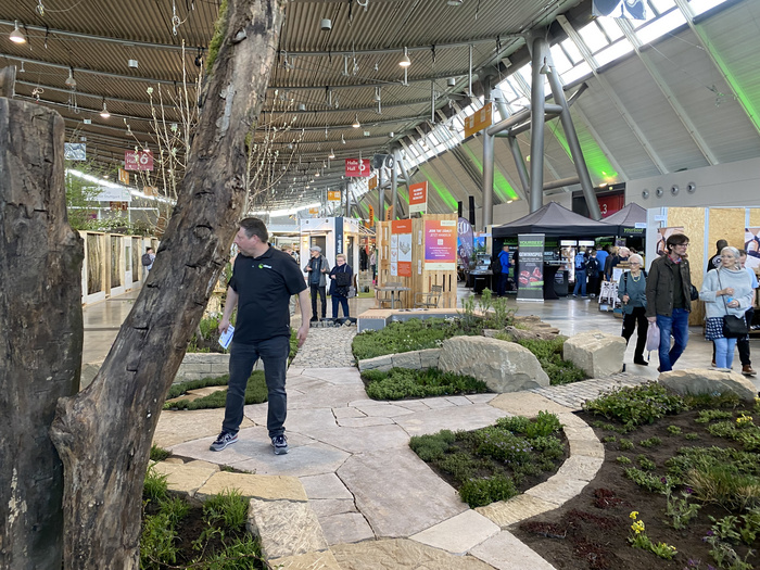 Ein Ausschnitt der Messe-Halle mit einem Stand zum Thema Garten und einer aufgebauten Garten- und Steinfläche.