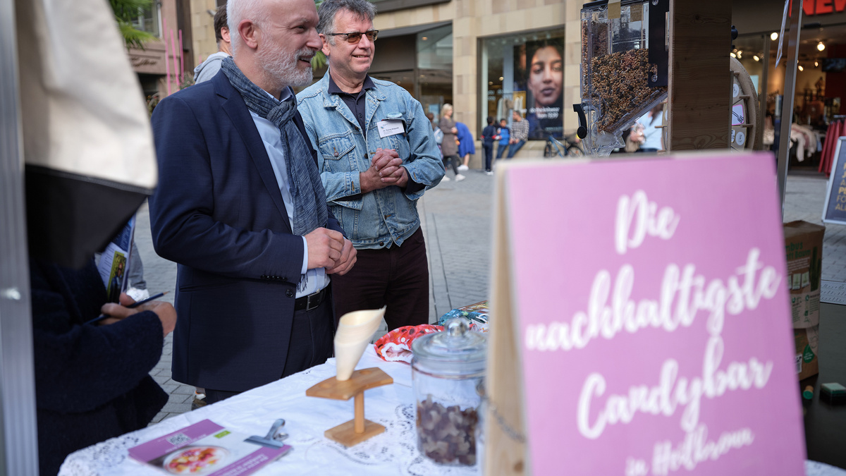 Zwei Männer stehen vor einem Stand mit dem Titel "Die nachhaltigste Candybar in Heilbronn".