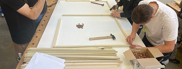 Jugendliche stellen Holzrahmen her.