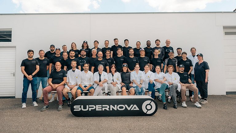 Team von Supernova stehend und sitzend hinter ihrem Logo.