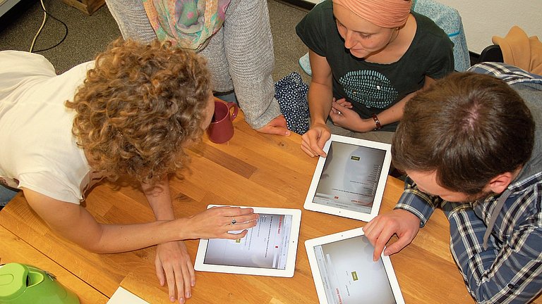 Nahaufnahme von Menschen, die auf Tablets etwas arbeiten.