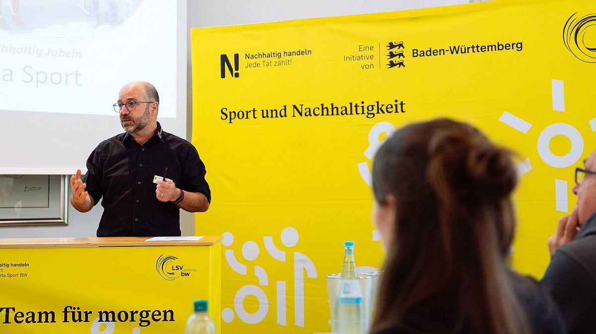 Mann spricht vor dem Rednerpult beim Vernetzungstreffen der N!-Charta Sport.