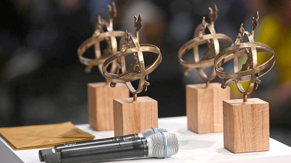 Vier SPOBIS Awards 2024 und zwei Mikrofone stehen auf einem Rednerpult.