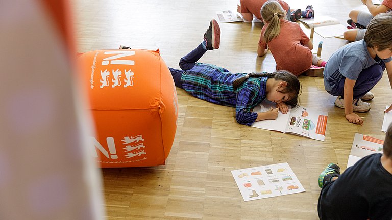 Kinder spielen mit dem Malbüchle Blubsi und Pupsi, die Bioabfall-Helden