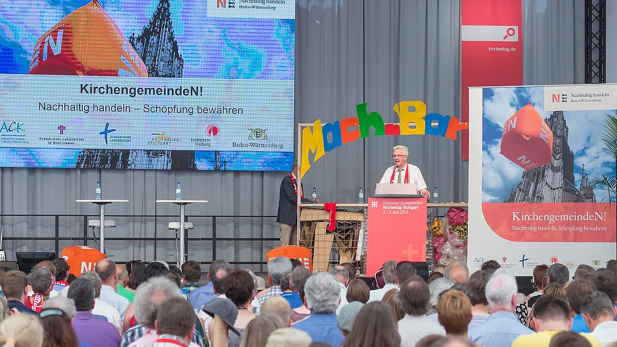 Auf der Aktionsbühne für den Wettbewerb „KirchengemeindeN! – nachhaltig handeln, Schöpfung bewahren“ auf dem Kirchentag 2015 spricht Minsterpräsident Manfred Kretschmann zum Publikum.