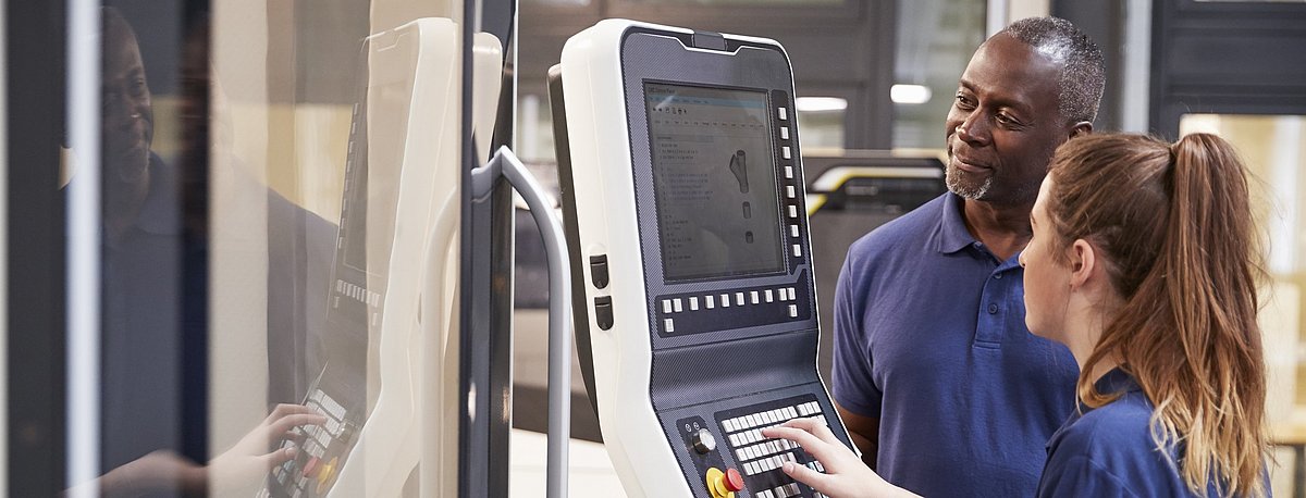 Arbeiterin und Arbeiter arbeiten an einem Terminal