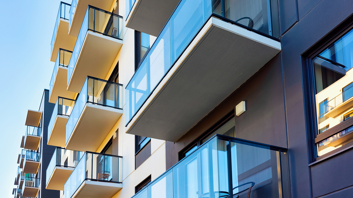 Zwei große städtische Wohnkomplexe bilden hintereinander eine Flucht. An der modernen Fassdenfront bilden Balkon mit ihren Glasverkleidungen ein grafisches Muster.