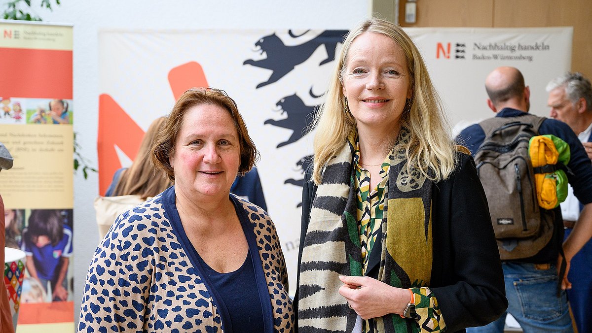 Kultusministerin Theresa Schober und Umweltministerin Thekla Walker stehen nebeneinander und lächeln in die Kamera.