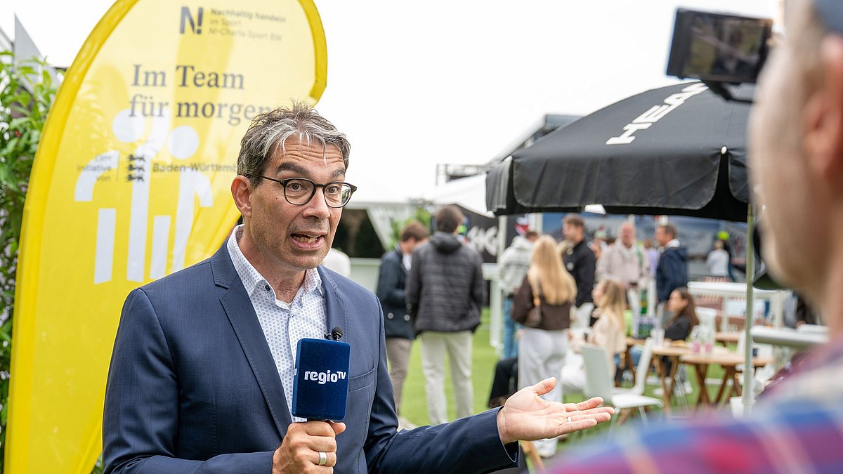 Staatssekretär Dr. Andre Baumann spricht mit den Menschen bei der BOSS OPEN.