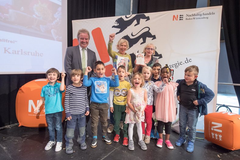 Herr Minister Franz Untersteller posiert mit jubelnden Kindern und zwei Erzieherinnen für ein Foto