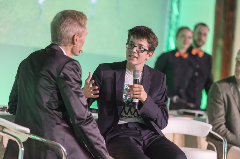 Nahaufnahme von Felix Finkbeiner, der auf der Bühne von seinem Projekt plant for the Planet erzählt