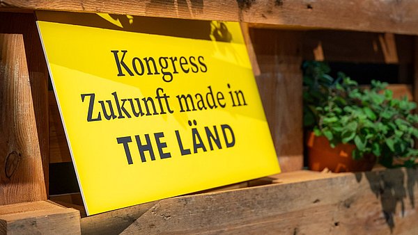 Schild mit schwarzer Schrift auf gelbem Hintergrund „Kongress Zukunft made in the LÄND"
