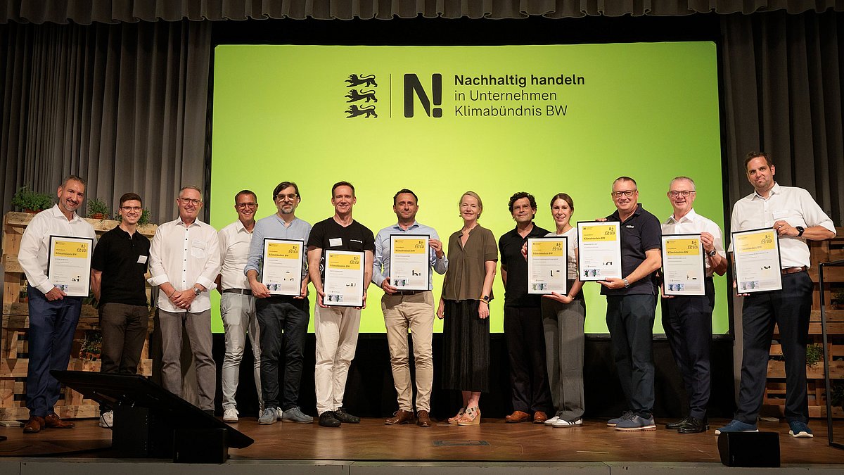 7 neue Klimabündnis-Unternehmen stehen mit Umweltministerin Thekla Walker MdL auf der Bühne.