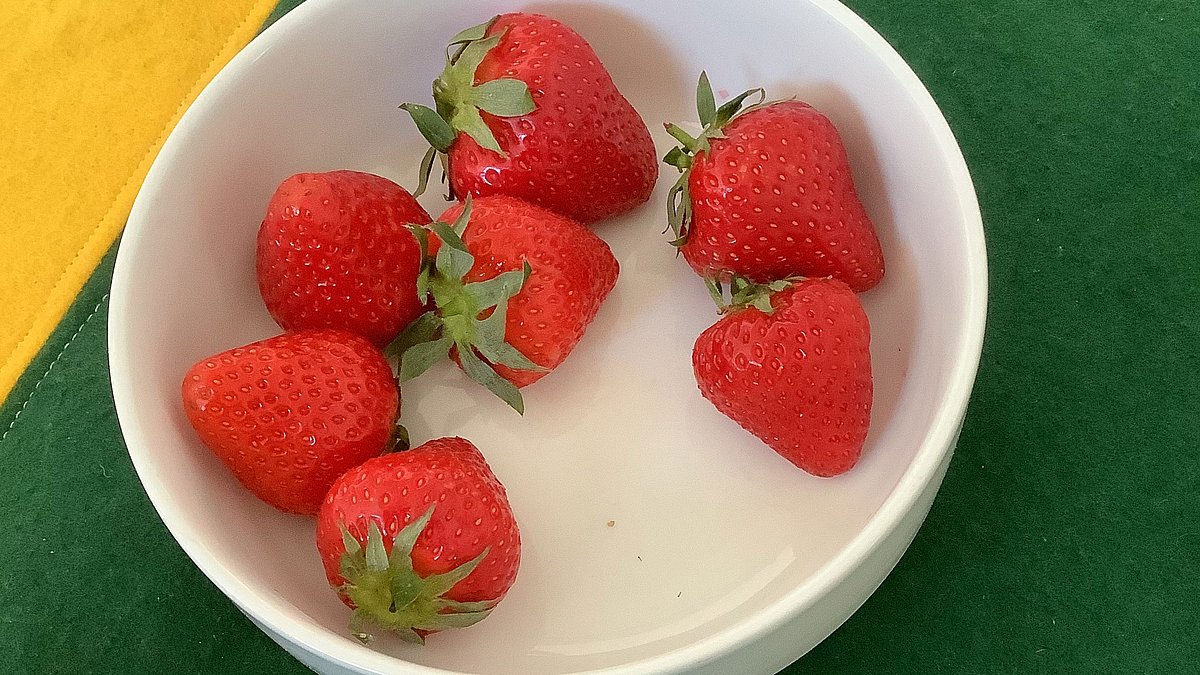 Wir besprechen, welches Obst regional und saisonal ist und welche Sorten per Flugzeug zu uns nach Deutschland transportiert werden. Danach lassen wir uns Erdbeeren schmecken.