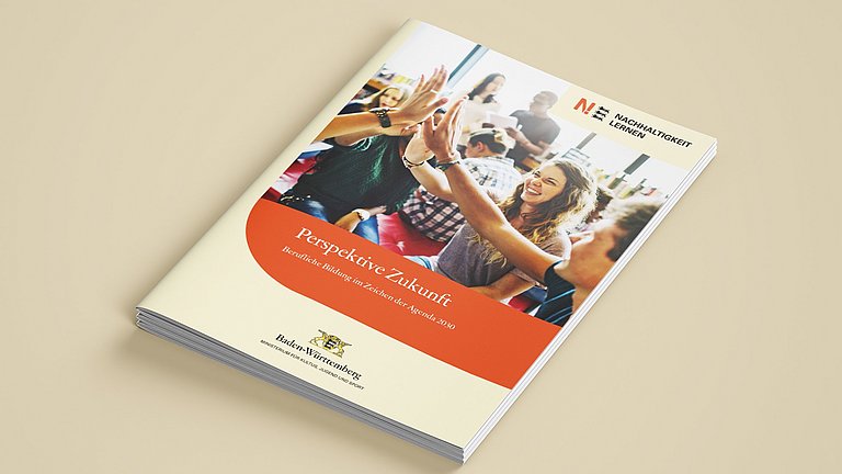 Mehrere Broschüren Perspektive Zukunft - Berufliche Bildung im Zeichen der Angenda 2030 liegen auf einem Arbeitsfläche.