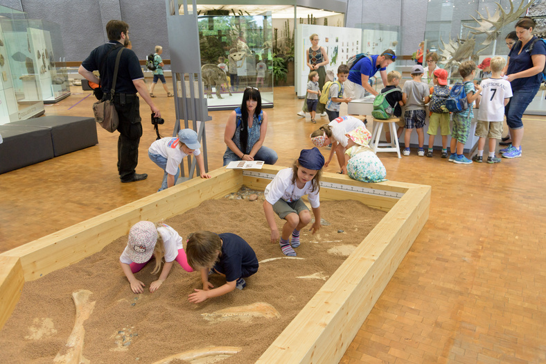 Kinder graben in nachgemachter Archäologen Ausgrabungsstätte