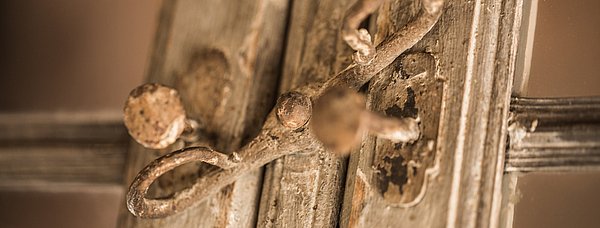 Das Bild zeigt eine Nahaufnahme eines historischen Fensterbeschlags.