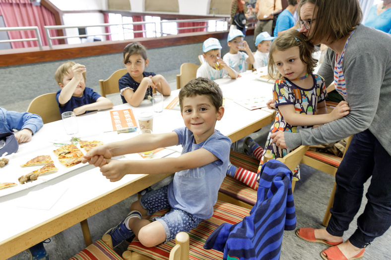 Kinder stärken sich mit Pizza und Getränken