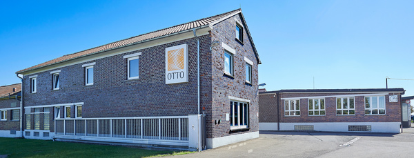 Zwei Gebäude der Gebrüder Otto GmbH & Co. KG mit Backsteinfassade.