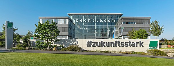 Unternehmensgebäude von Bechtle mit Glasfront und der Aufschrift bechtle.com. Davor eine Mauer mit der Aufschrift #zukunftsstark.