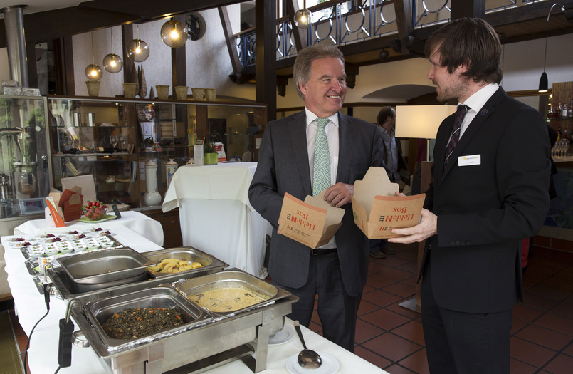 Umweltminister Untersteller und Arnold Nölly mit Helden-Boxen vor einem Buffet