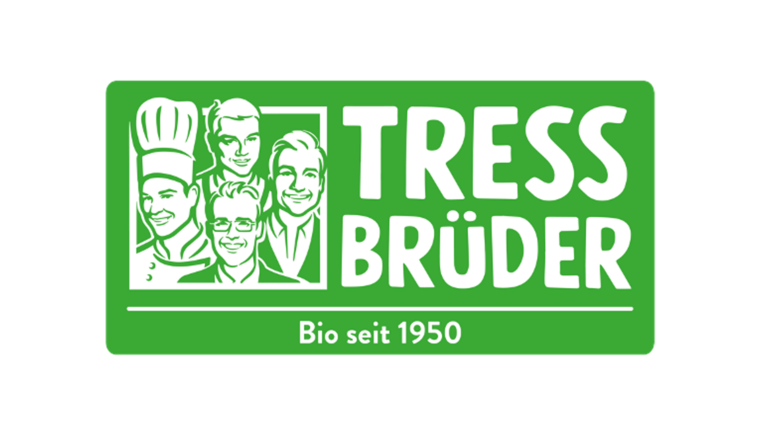 Logo von TressBrüder: Vier weiß gezeichnete Köpfe von Männern auf grünem Grund. Darunter der Schriftzug: „Tress Brüder Bio seit 1950“