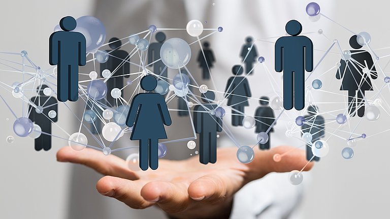 Im Fokus des Bildes eine ausgestreckte Hand, auf der mehrere blaue Strichmännchen in in verschiedenen Positionen stehen und durch Striche und Kreise miteinander verbunden sind. 