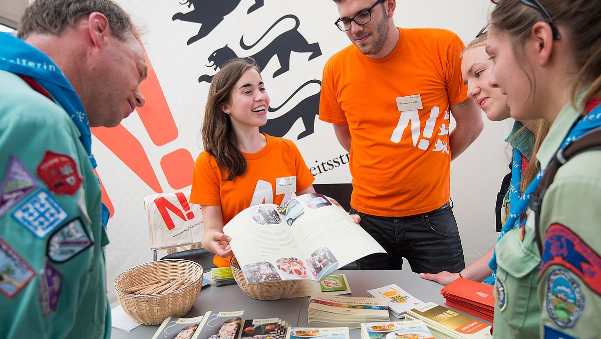 Zwei Vertreter der Nachhaltigkeitsstrategie Baden-Württemberg beraten Besucher des Kirchentages 2015 zu Themen der Nachhaltigkeit.