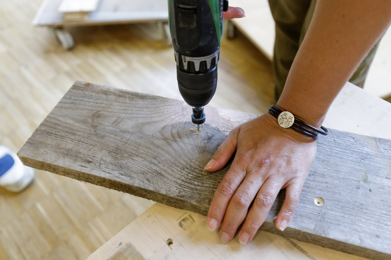 Bohrer durchbohrt ein Holzbrett