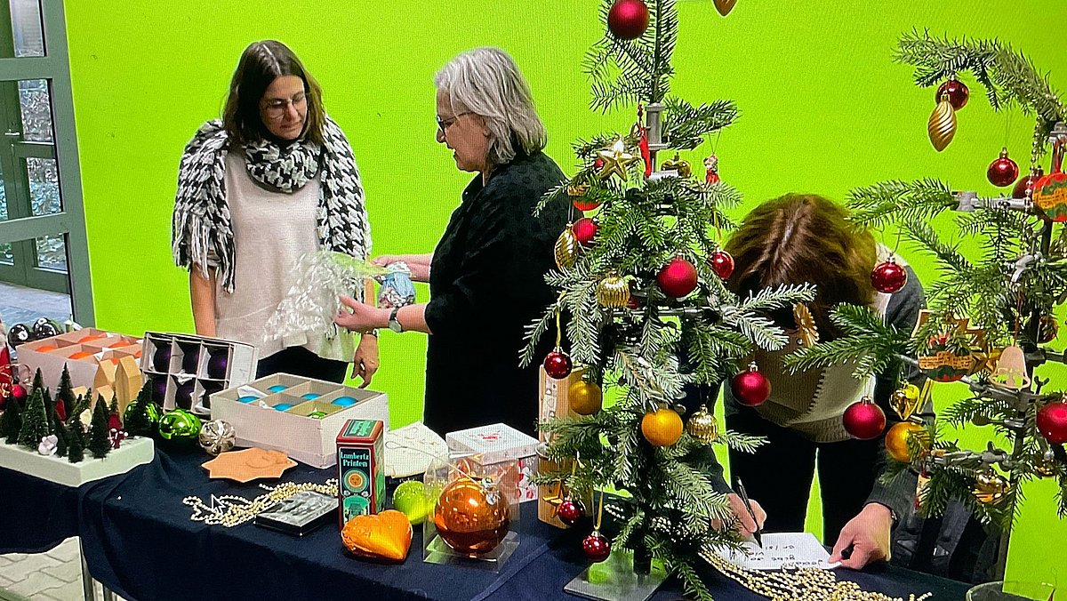 Stand der Weihnachtstauschbörse mit drei Frauen hinter dem Stand.