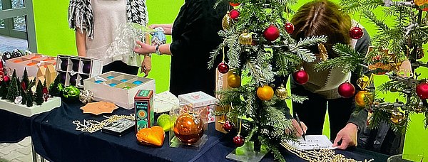 Stand der Weihnachtstauschbörse mit drei Frauen hinter dem Stand.