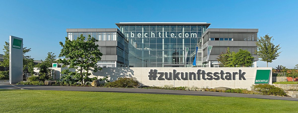 Unternehmensgebäude von Bechtle mit Glasfront und der Aufschrift bechtle.com. Davor eine Mauer mit der Aufschrift #zukunftsstark.