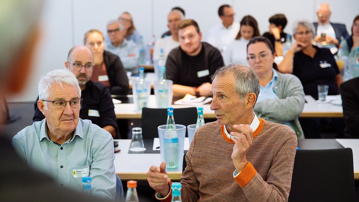 Teilnehmende beim Vernetzungstreffen sitzen im Saal