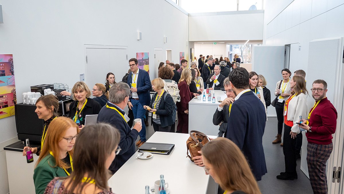 Besucherinnen und Besucher des Kongresses stehen im Foyer.
