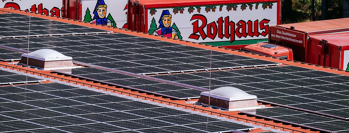 Ein Teil der PV-Anlage auf den Dächern von der Brauerei Rothaus. Im Hintergrund sind mehrere LKWs mit der Aufschrift Rothaus und dem Logo zu sehen.
