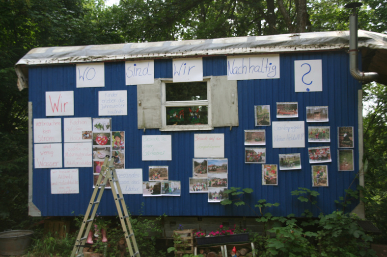 Aufnahme einer mit Bildern und Aufschrieben beklebten Containerwand des Waldkindergarten