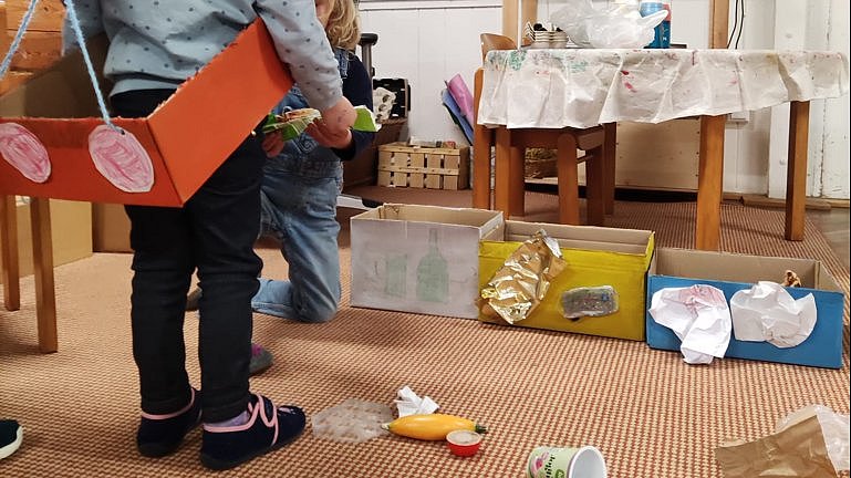 Thema Müllsammeln im Morgenkreis - Ein Kind darf das "Müllauto" fahren.