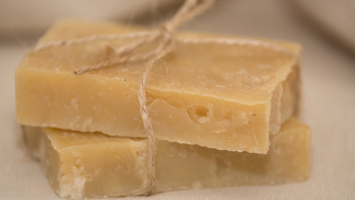 Zwei Seifenstücke aus natürlichen Rohstoffen liegen übereinander mit einer Sisalschnur zusammengebunden.