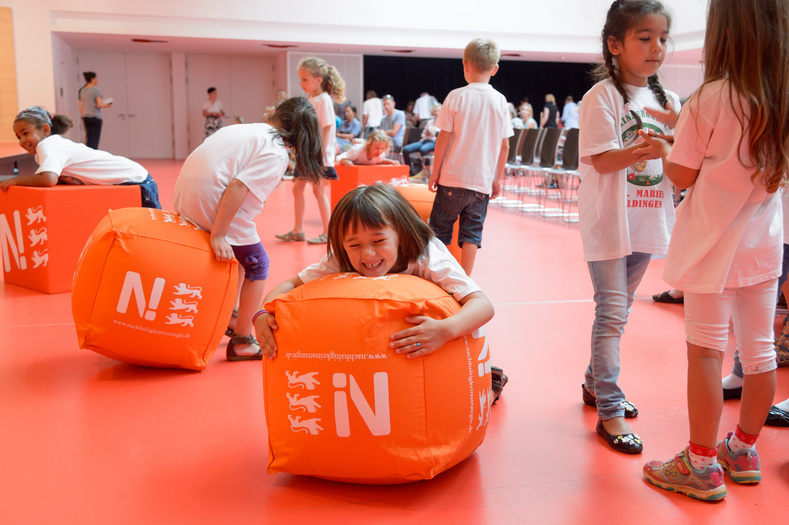 Kinder spielen auf orangenen Bällen der Nachhaltigkeitsstrategie