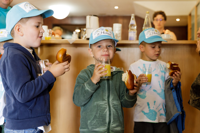 Kleine HeldeN! 2017 Drei Jungs mit gleicher blauer Kappe essen Brezeln und trinken Orangensaft