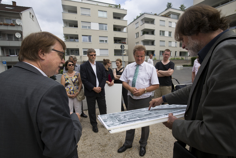 der Landschaftsarchitekt Michael Glück erläutert eine Gruppe von Menschen inklusive Herr Franz Untersteller etwas zum Thema nachhaltiges Bauen