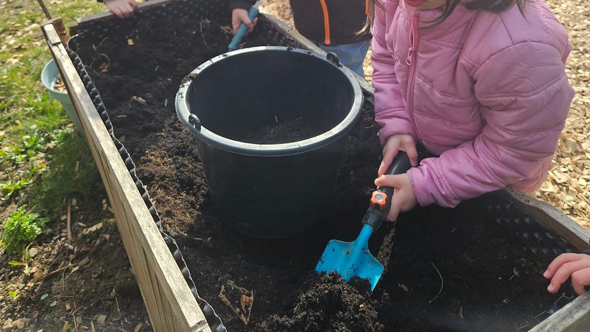 Hochbeet vorbereiten um Gemüse und Erdbeeren einzupflanzen.