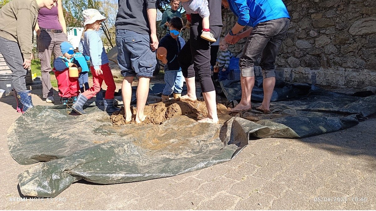 Hier sieht man wie Eltern und Kinder zusammen den Lehn vorbereiten. Die Zusammenarbeit hat die Gruppe gestärkt.