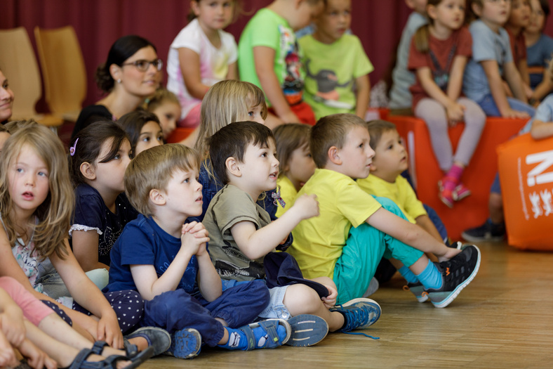 auf dem Boden sitzende Kinder hören gespannt zu