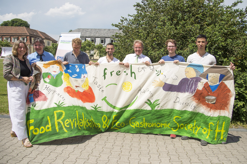 Eine Gruppe von Menschen hält zusammen mit Umweltminister Untersteller ein selbstbemaltes Banner in die Kamera